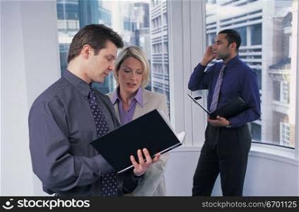 men and woman meeting and discussing document in office