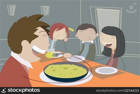 Men and women eating food at the dining table