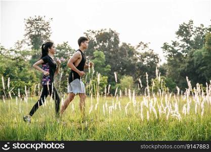 Men and women exercise by running on the streets with trees and flowers.