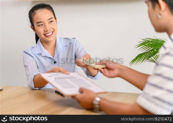 Men and women sign contracts and pay in the office.