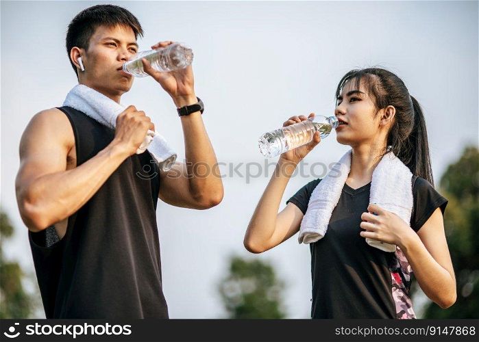 Men and women stand to drink water after exercise. Selective focus.