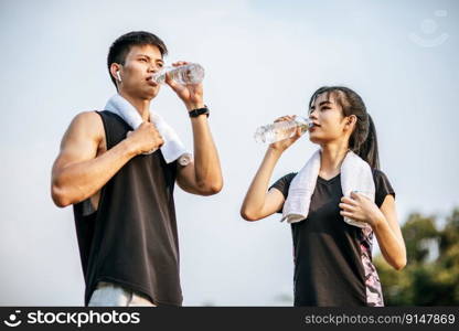 Men and women stand to drink water after exercise. Selective focus.