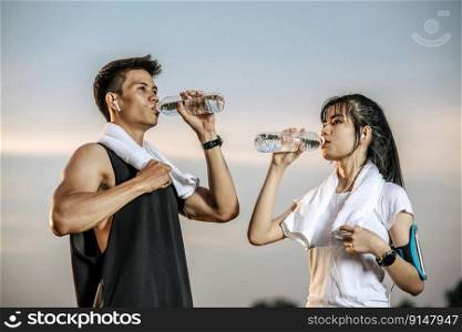 Men and women stand to drink water after exercise. Selective focus.