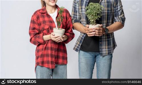 Men and women standing and holding plant pots in the house
