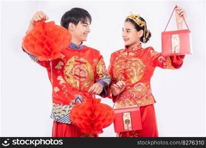 Men and women wearing cheongsam Standing holding red bag and honeycomb lantern