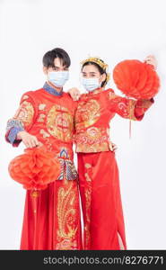 Men and women wearing qipao and wearing face masks Stand with honeycomb l&