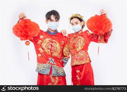 Men and women wearing qipao and wearing face masks Stand with honeycomb l&