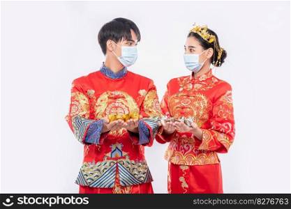 Men and women wearing Qipao and wearing masks Spend with gold money