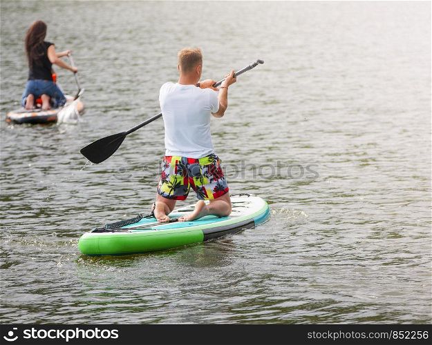 Men and women with her baby stand up paddle boarding (sup)