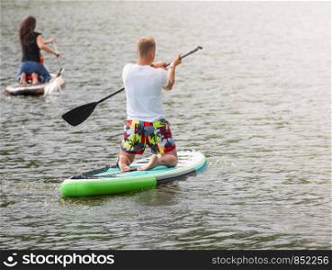 Men and women with her baby stand up paddle boarding (sup)