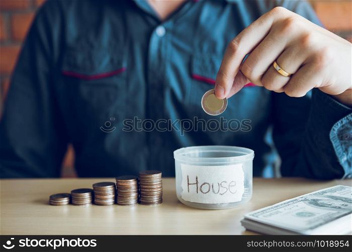 Men are holding coins dropping to the money box with the concept of saving.