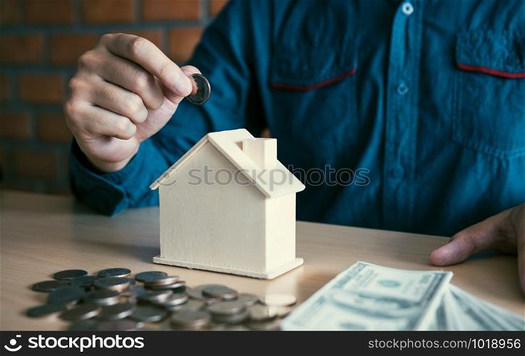 Men are putting coins together with the idea of collecting money to buy a new house.