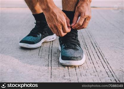 Men are tying up their feet. Before going to jogging,Men are binding shoes