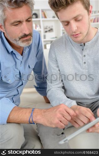 men at home with tablet