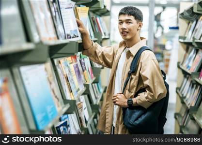 men carrying a backpack and searching for books in the library.