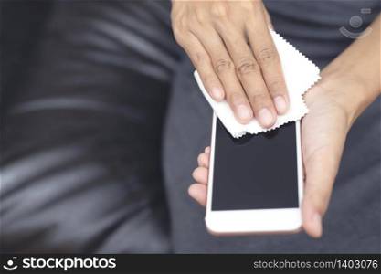 Men clean mobile phones to prevent Covid 19 virus and bacteria