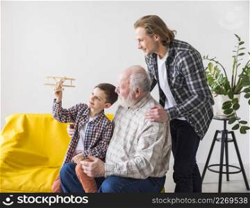 men different generations looking toy plane