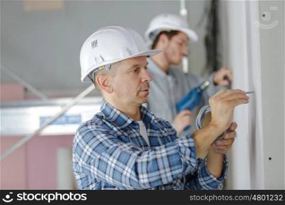 men drilling the wall with drill perforator