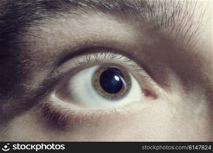 Men eye with red blood vessels closeup