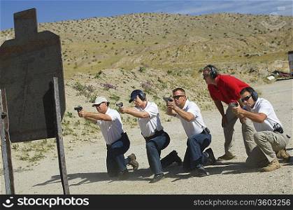 Men firing guns at shooting range