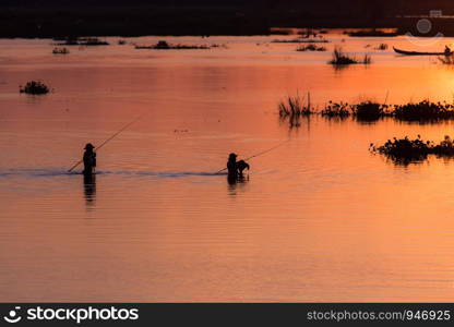 Men fishing on the Lake at sunset scene in Mandalay, Myanmar