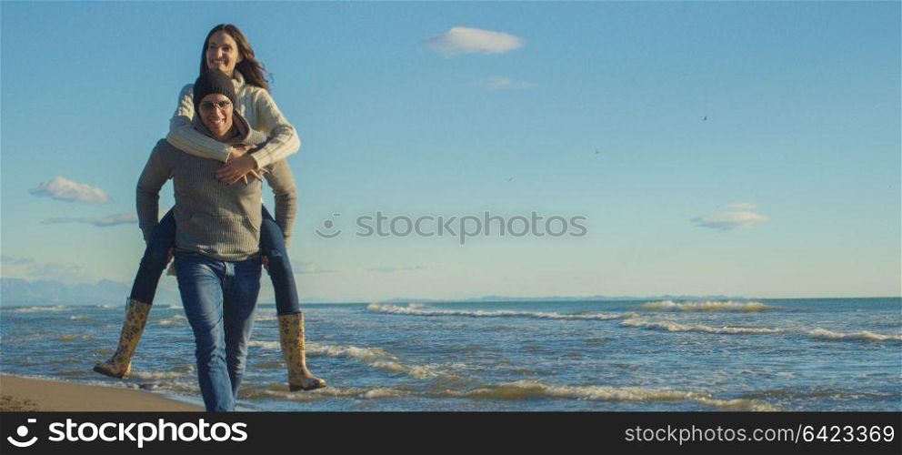 Men Giving Piggy Back Rides At Sunset By The Sea, autumn time