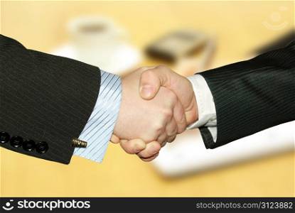 Men handshake over paper and pen