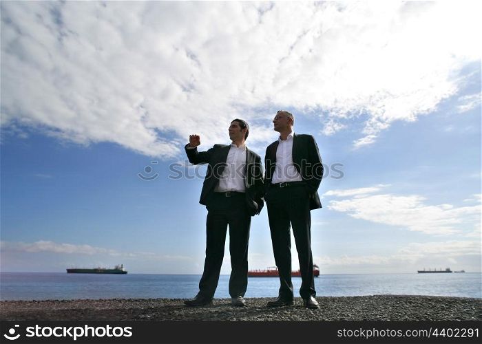 Men in suit chatting at the seaside