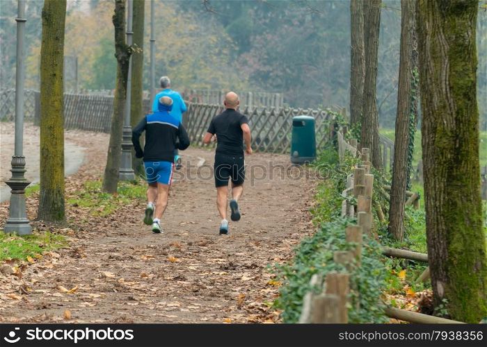 Men jogging in park in autumn. Health and fitness