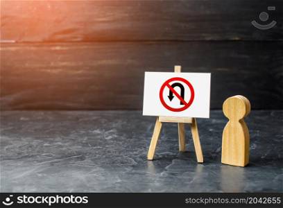 Men near no turning back traffic sign easel. Turn arrow and red prohibition symbol. Assertiveness and striving, moving forward without retreating. Finish goals. Obstinacy, irrevocability. No way back.