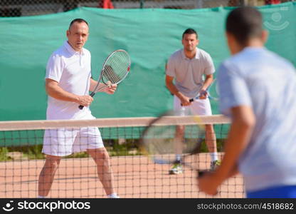 Men playing tennis doubles