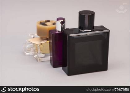 men&rsquo;s and woman perfume in bottles on gray background