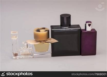 men&rsquo;s and woman perfume in bottles on gray background