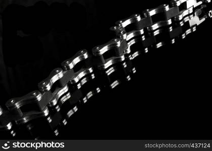Men's bracelet in the shape of the bicycle chain with mirror reflection isolated on black background with sample text