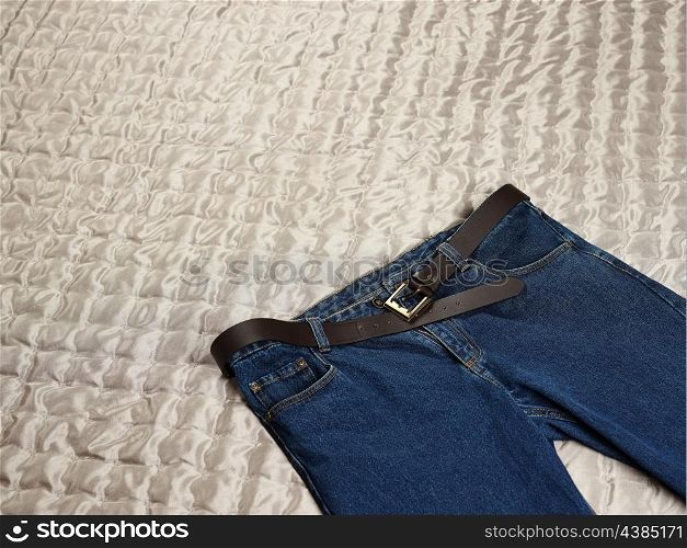 Men&rsquo;s casual blue jeans on the bed