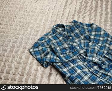 Men&rsquo;s casual checkered shirt on the bed