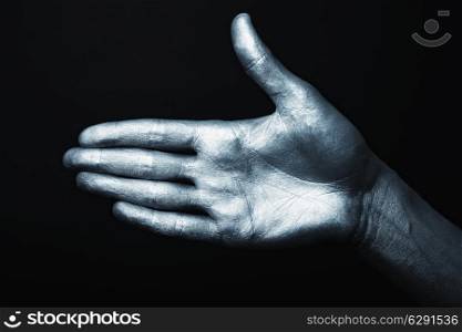Men&rsquo;s hand in a silver paint isolated on black background