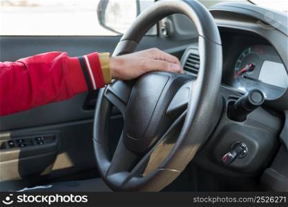 men&rsquo;s hand with a watch on the steering wheel of a modern car. hand on the steering wheel