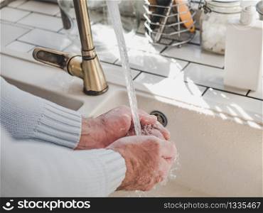 Men&rsquo;s hands and a bar of soap on a background of a vintage tap. Top view, closeup. Health Care and Prevention Concept. Men&rsquo;s hands and a bar of soap