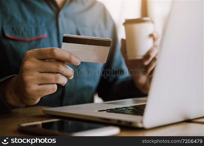 Men&rsquo;s hands are holding smart phones and drinking coffee with shopping online concept.