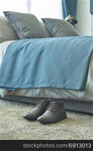 Men&rsquo;s shoe on light green carpet in the bedroom