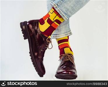 Men’s legs, trendy shoes and bright socks. Close-up. Style, beauty and elegance concept. Men’s legs, trendy shoes and bright socks