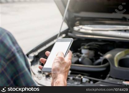 Men?s right hand is using a smartphone to contact. The vehicle is experiencing problems or accidents, mockup phone concept.