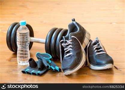 Men's sneakers and dumbbell on the floor in the gym close-up