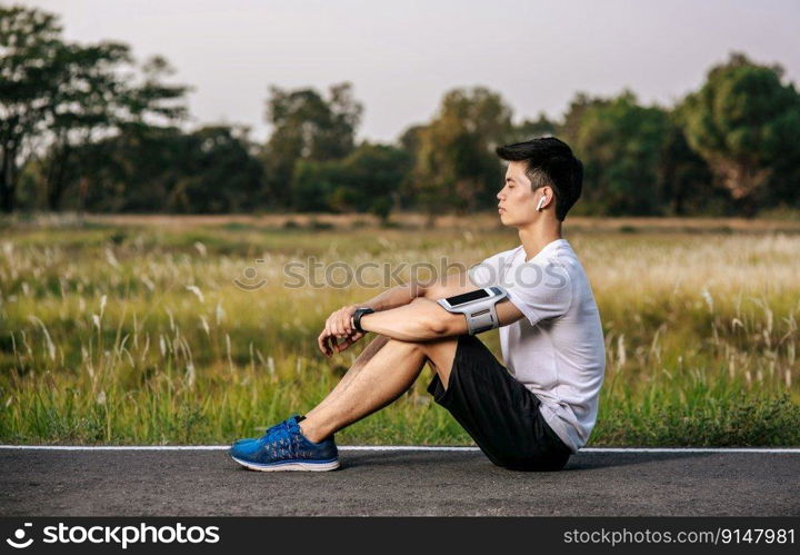 Men sitting and resting after exercising on the roadside. Selective focus