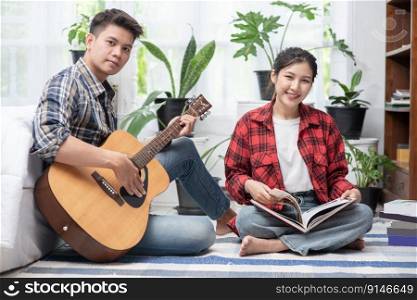 Men sitting guitar and women holding books and singing.