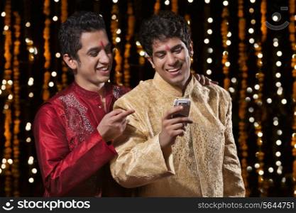 Men smiling at sms on mobile phone