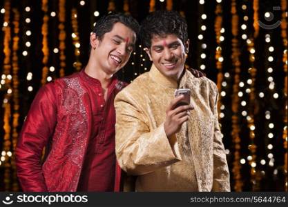 Men smiling at sms on mobile phone