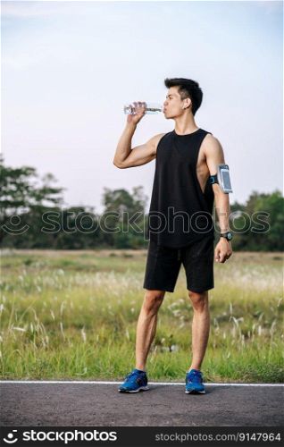 Men stand to drink water after exercise. Selective focus.