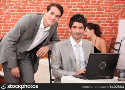 Men using a laptop in a restaurant